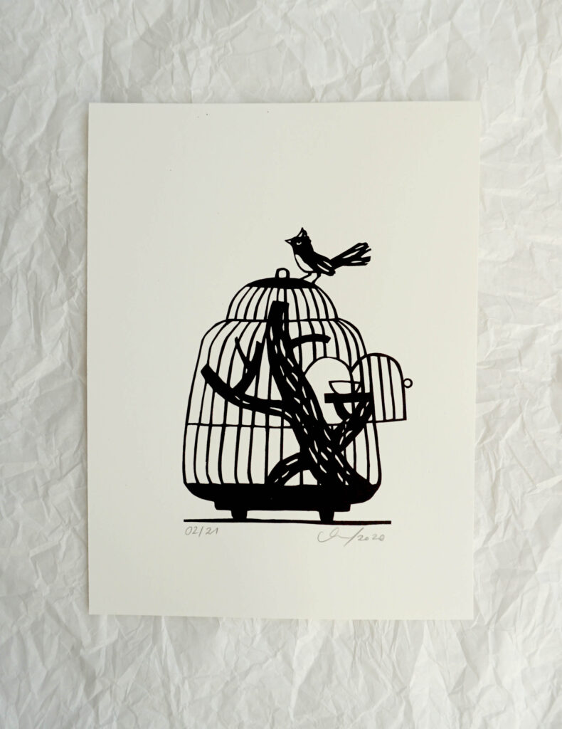 ein Vogel sitzt auf einem Vogelkäfig dessen Tür offen steht. Die Grafik ist mit der Farbe schwarz gedruckt und als Vorlage für den Druck habe ich einen Scherenschnitt mit dem Motiv angefertigt. 
